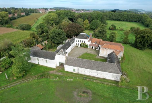 A striking farm around a quadrangle with 3 ha of grounds  in Wallonia, close to the French border