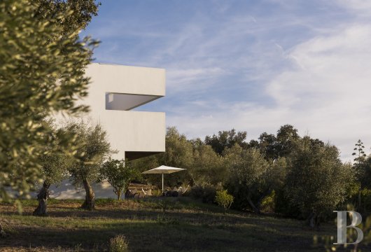 In the Alentejo region, 20 km from Évora, a contemporary villa and its outbuildings in a century-old olive grove ...