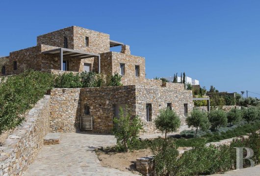 In the hills of Sifnos, a stone villa with two self-contained guest houses overlooking the Aegean Sea