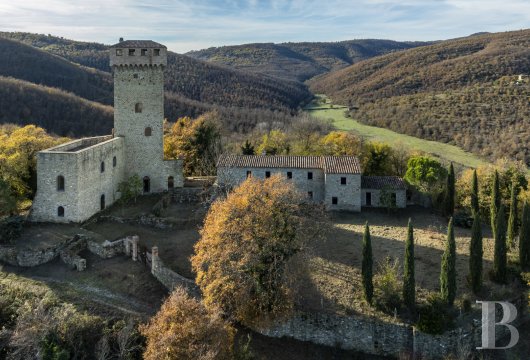 In Umbria, a medieval castle with a 35-metre tower, in need of renovation, situated between Lake Trasimeno, Perugia ...